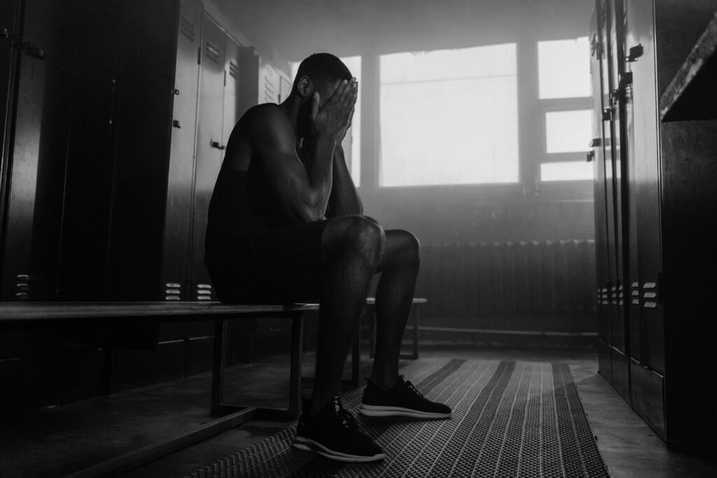 Sportif dans un vestiaire se demandant comment il va gérer son stress en compétition